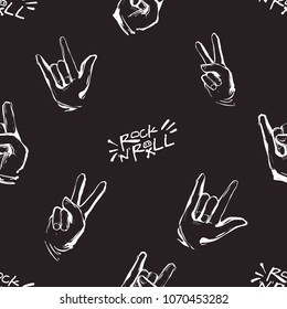 Rock and roll seamless pattern with rock'n'roll text sign, peace and rock gestures. Vector hard rock doodle illustration. Cartoon rock backdrop for music band, concert, party with black background.
