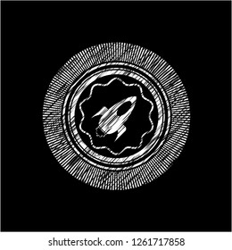 rocket icon inside chalkboard emblem on black board