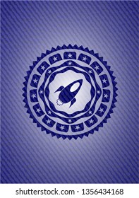 rocket icon inside emblem with jean background