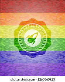 rocket icon inside emblem on mosaic background with the colors of the LGBT flag