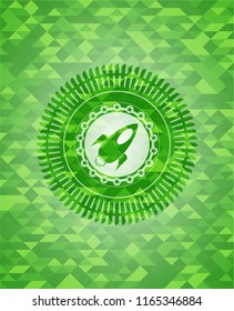 rocket icon inside green emblem with triangle mosaic background