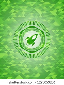 rocket icon inside green emblem with mosaic background