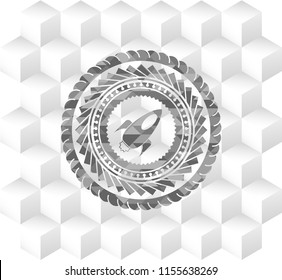 rocket icon inside grey emblem with geometric cube white background