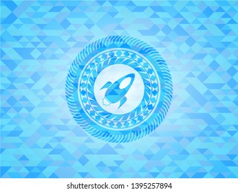 rocket icon inside light blue mosaic emblem