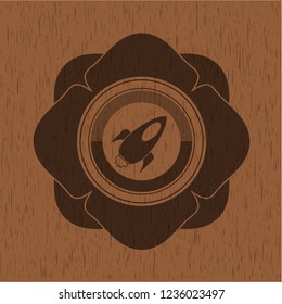 rocket icon inside realistic wood emblem
