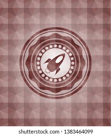 rocket icon inside red seamless badge with geometric pattern.