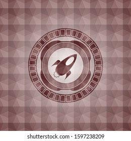 rocket icon inside red seamless emblem with geometric pattern.
