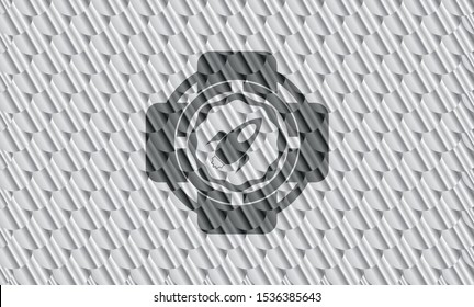 rocket icon inside silver shiny badge. Scales pattern. Vector Illustration. Detailed.