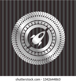 rocket icon inside silvery badge