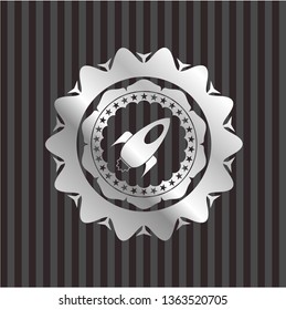 rocket icon inside silvery emblem or badge