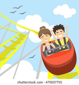 Rollercoaster In Amusement Park. Young Smiling Man And Woman Have Fun On The Roller Coaster. Scary But Funny Entertainment.