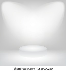 The room is empty, white, with a light shining in the middle, which has a pedestal.