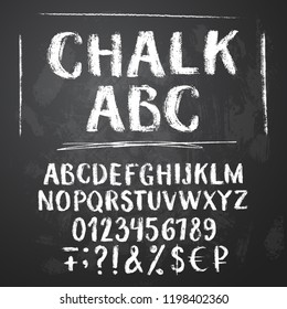 Rough chalk latin alphabet on textured chalkboard background. Uppercase letters, numbers, sumbols, money signs.