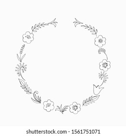 Round black and white frame of twigs, leaves and flowers.