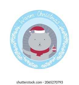 Round card with a cute hedgehog in a hat and a scarf with the text "Warm Christmas". Vector illustration for cards, invitations, stickers, t-shirts, labels