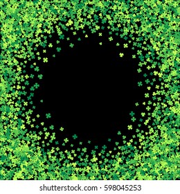 Round green frame, border or background of random scatter clover leaves. Elegant St. Patricks day design for festive banner, greeting card, postcard, flyer. Vector illustration.