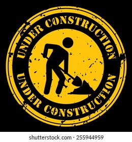 Round icon with the words Under Construction with a man shoveling in black and yellow.