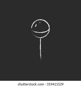 Round lollipop hand drawn in chalk on a blackboard vector white icon isolated on a black background.