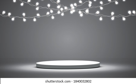 
Round podium, pedestal or platform illuminated by spotlights on a gray background, holiday lanterns.