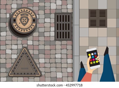 Round steel sewer manhole on the cobblestone road. Cast iron drain cover on the street. Vintage triangle cast iron hatch cover. Person hold smart phone walking along the pavement. Vector illustration