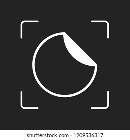 Round sticker with bent edge. White object in camera autofocus on dark background