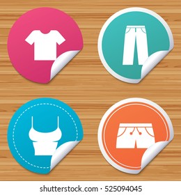 Round stickers or website banners. Clothes icons. T-shirt and pants with shorts signs. Swimming trunks symbol. Circle badges with bended corner. Vector