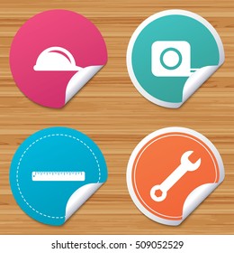 Round stickers or website banners. Construction helmet and wrench key tool icons. Ruler and tape measure roulette sign symbols. Circle badges with bended corner. Vector