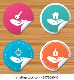 Round stickers or website banners. Helping hands icons. Financial money savings insurance symbol. Home house or real estate and lamp, key signs. Circle badges with bended corner. Vector