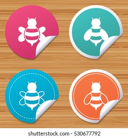 Round stickers or website banners. Honey bees icons. Bumblebees symbols. Flying insects with sting signs. Circle badges with bended corner. Vector