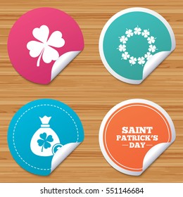 Round stickers or website banners. Saint Patrick day icons. Money bag with coin and clover sign. Wreath of quatrefoil clovers. Symbol of good luck. Circle badges with bended corner. Vector