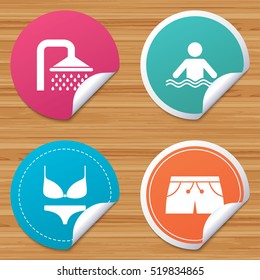 Round stickers or website banners. Swimming pool icons. Shower water drops and swimwear symbols. Human stands in sea waves sign. Trunks and women underwear. Circle badges with bended corner. Vector