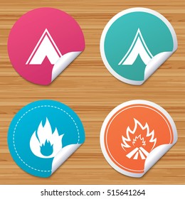 Round stickers or website banners. Tourist camping tent icons. Fire flame sign symbols. Circle badges with bended corner. Vector