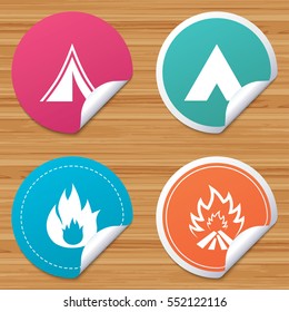 Round stickers or website banners. Tourist camping tent icons. Fire flame sign symbols. Circle badges with bended corner. Vector