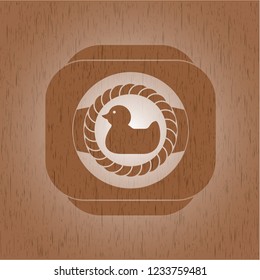 rubber duck icon inside badge with wooden background