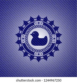 rubber duck icon inside emblem with jean background