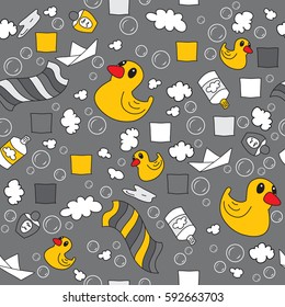 Rubber duck, shampoo, towel, paper boat among the foam and soap bubbles