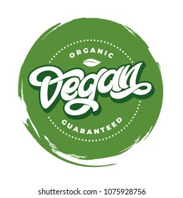 Rubber stamp effect and hand lettering of the text ORGANIC VEGAN GUARANTEED on white isolated background. Handwritten lettering for restaurant, cafe menu.