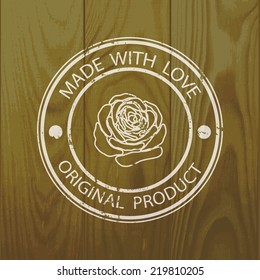 Rubber stamp with  text Made With Love and rose silhouette on wooden background. For scrapbook or any other design.