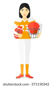 Rugby player with ball and helmet in hands.