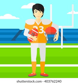 Rugby player with ball and helmet in hands.
