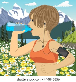 runner woman with smartphone armband listening to music on mobile phone app drinking bottled mineral water jogging in mountains