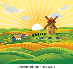 Rural landscape with a windmill, village and herd cows on the background of sunset.