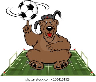 Russian bear in a cap with earflaps sitting on a football field. Football championship, soccer. Russia 2018 World Cup