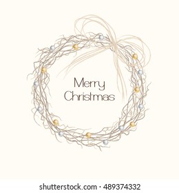 Rustic Christmas wreath made from twigs and decorated with small gold and silver baubles.