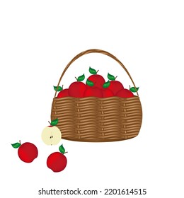 Rustic wicker basket full of  ripe red apples with green leaf and half of apple on white background with copy space.