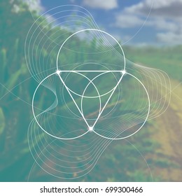 Sacred geometry interlocking circles flower of life ancient symbol with triangle and unfocused vector photo background.