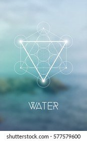 Sacred geometry Water element symbol inside Metatron Cube and Flower of Life in front of natural blurry background.