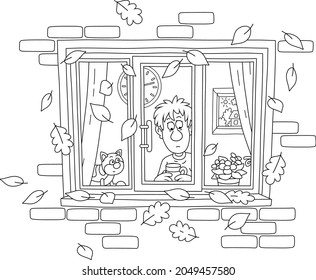 Sad boy and his funny cat looking out of a window with flying autumn leaves, black and white outline vector cartoon illustration for a coloring book page
