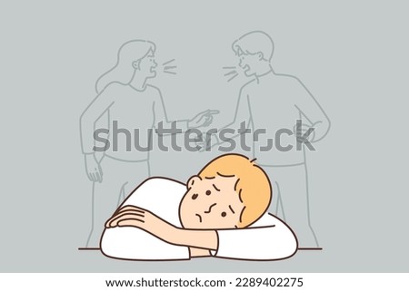 Sad boy sits alone near conflict of parents not paying attention to son. Concept of family conflict and problems in relationships that harm upbringing of child and cause psychological troubles 