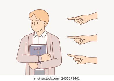 Sad christian man with bible, feeling persecution and oppression because of religion, from people pointing fingers. Christian guy hugs holy book, refusing to change religion despite demands of society